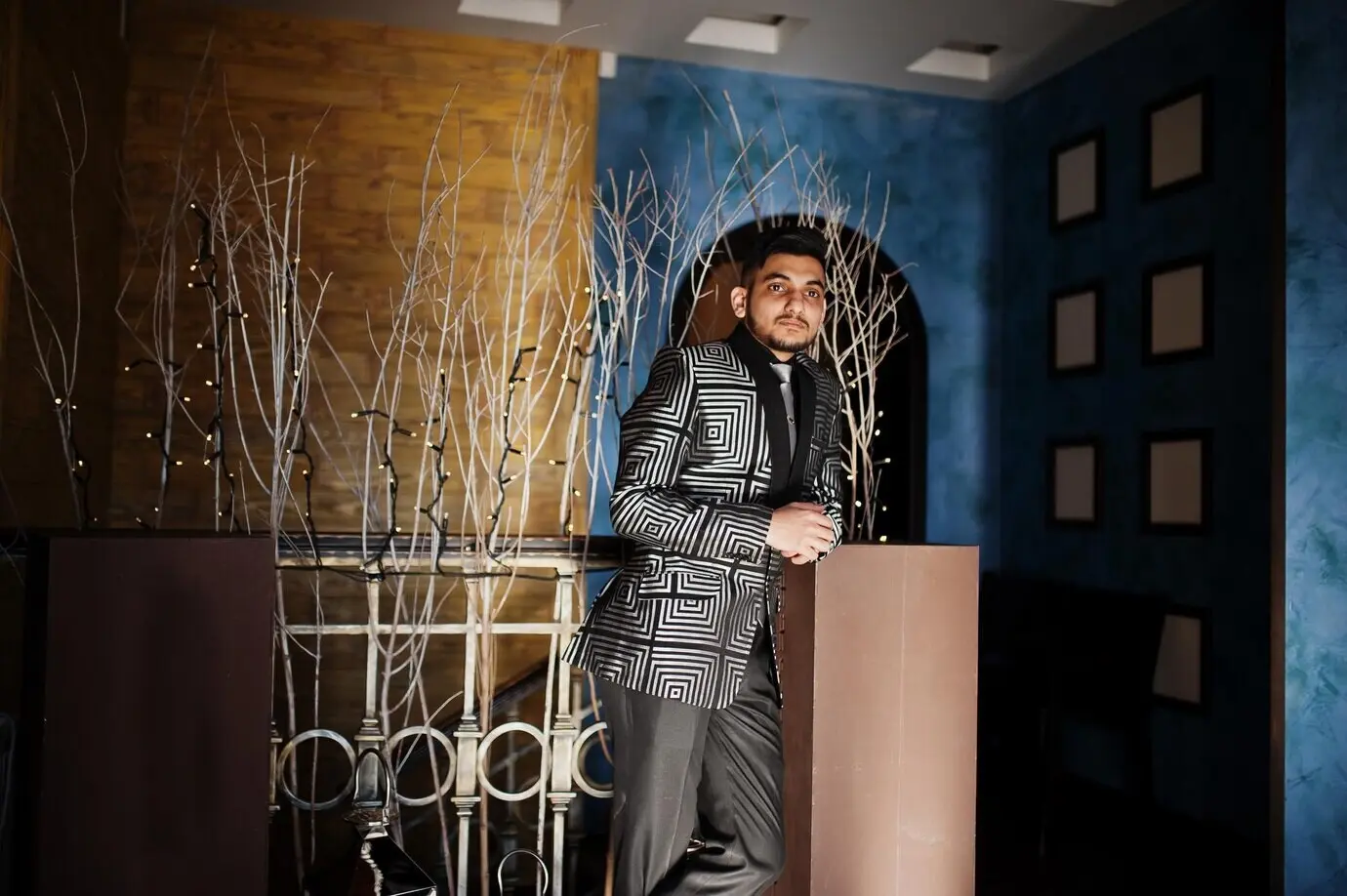 Молодой красивый индийский бизнесмен в вечернем костюме в ресторане.